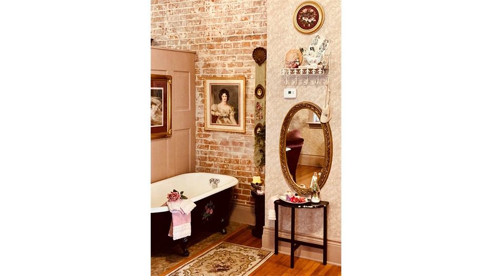 Victorian soaking tub beneath a chandelier