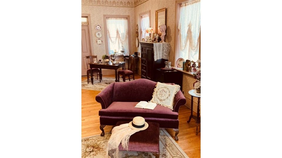 Sitting area with velvet loveseat in The Milliner's Bedchamber Cottage