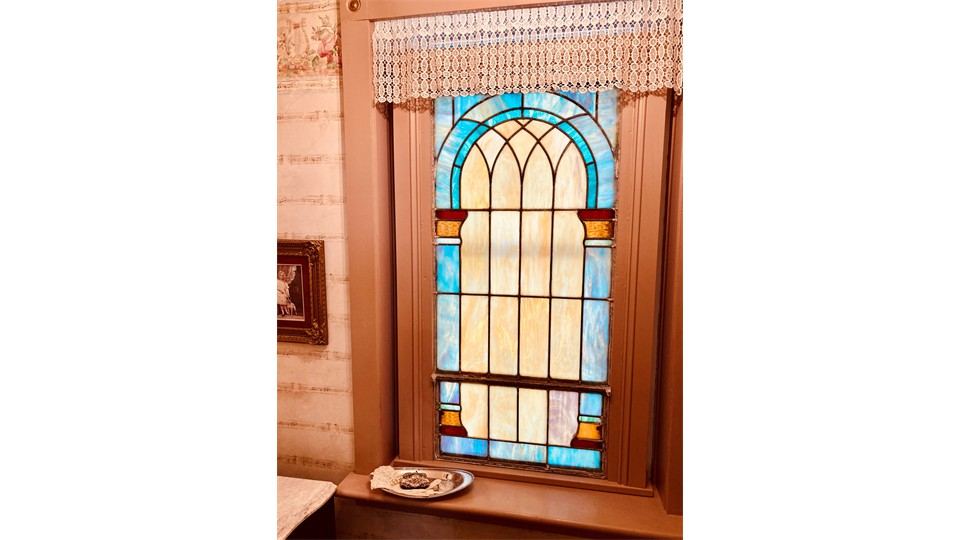Antique stained glass window in the Milliner's powder room