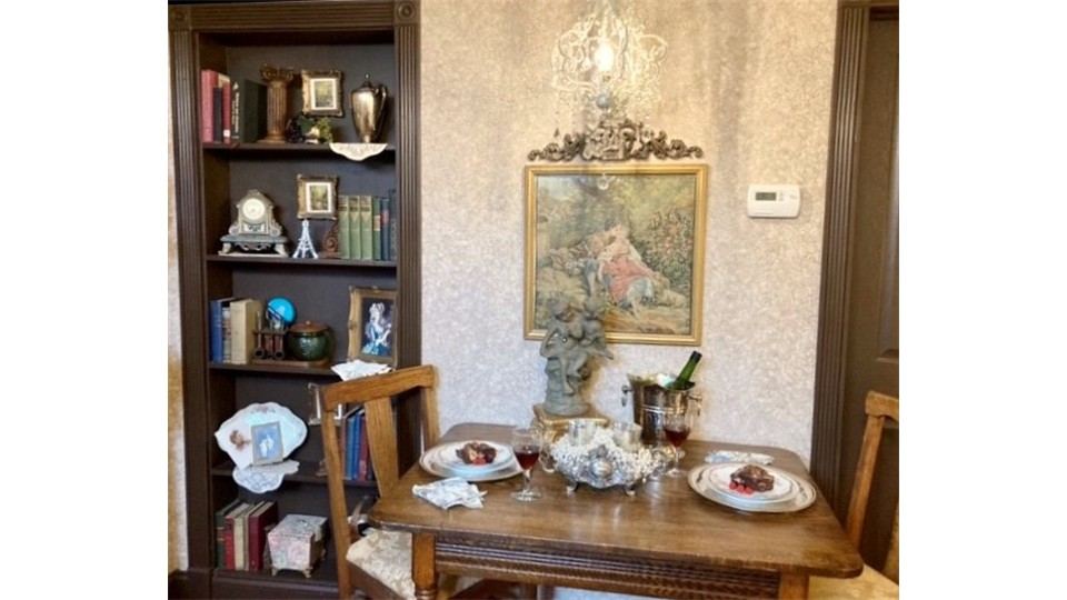 Dining table and bookcase in the Parisian Dreams Bedchamber Suite