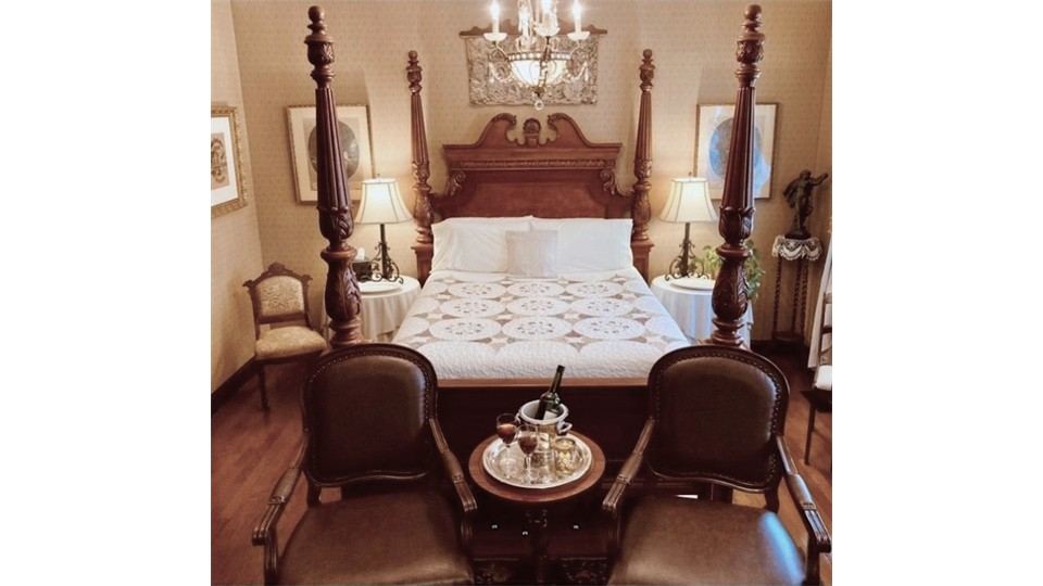 Four poster bed with leather armchairs in the Schiller Strasse Parlor Suite
