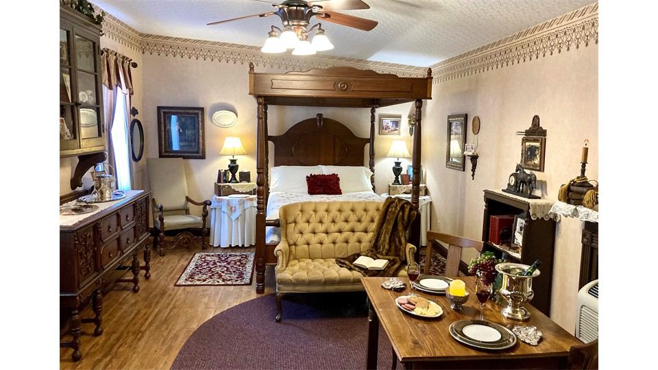 Canopied bed and sitting area in The Happy Wanderer Cottage